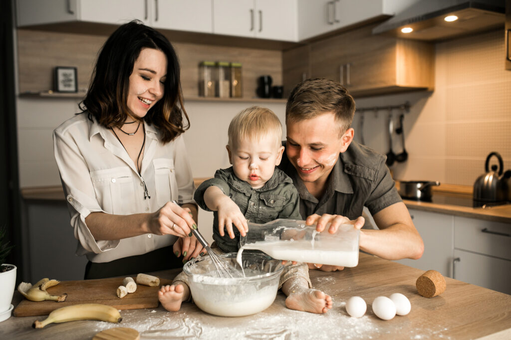 Famille souriante cuisinant ensemble dans leur cuisine